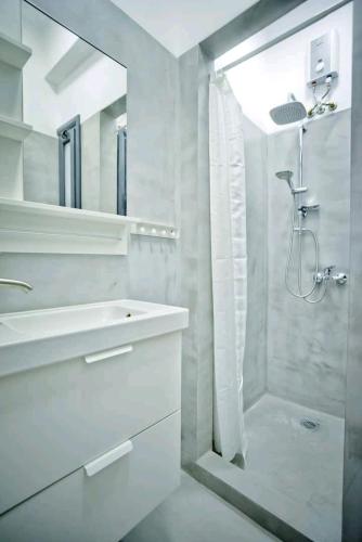 a white bathroom with a shower and a sink at The old Tailor Factory White Room in Athens