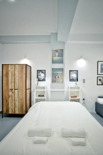 a white bedroom with a large bed with two pillows at The old Tailor Factory White Room in Athens