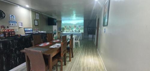 una sala da pranzo con tavolo e sedie in un ristorante di Phuenics de galera a Puerto Galera