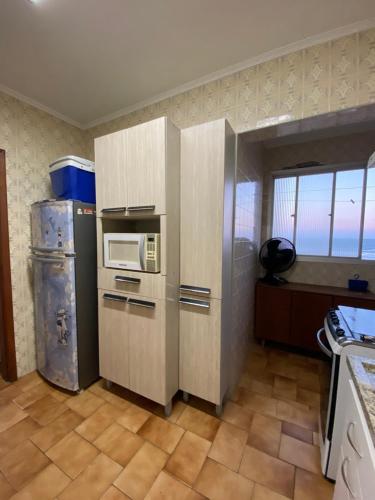 a kitchen with a refrigerator and a microwave at REFÚGIO DA SEREIA ARIEL in Mongaguá