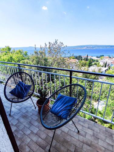 two chairs with blue pillows sitting on a balcony at Apartmani Ankica in Crikvenica
