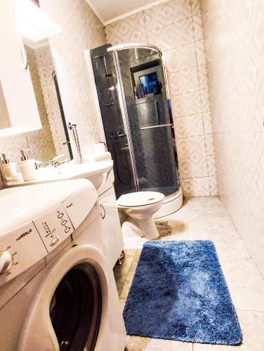 a bathroom with a shower and a washing machine at Apartmani Ankica in Crikvenica