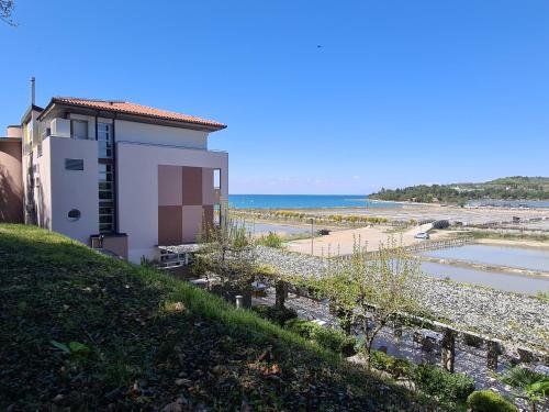 a building on a hill next to a beach at Hotel Oleander - Oleander Resort in Strunjan