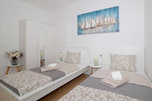 a bedroom with two beds and a painting on the wall at Studio Apartman Karlita in Slano