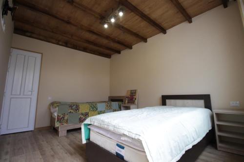 una camera con letto bianco e soffitto in legno di Mardoyan's Guest house a Gavarr