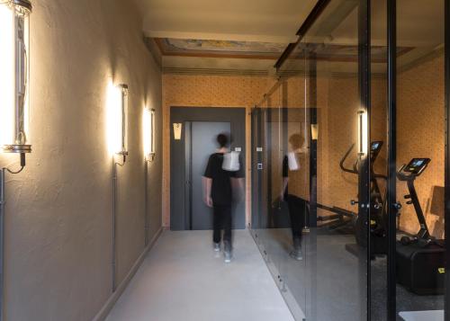 a woman walking down a hallway in a building at Antica Dimora Le Misure in Cervia