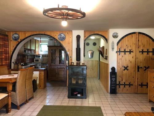 a kitchen with two arched doors and a wood stove at Szendergő - Apartman Hajós pincefalu in Hajós