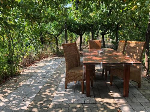 una mesa de madera y sillas en un patio de ladrillo en Szendergő - Apartman Hajós pincefalu, en Hajós