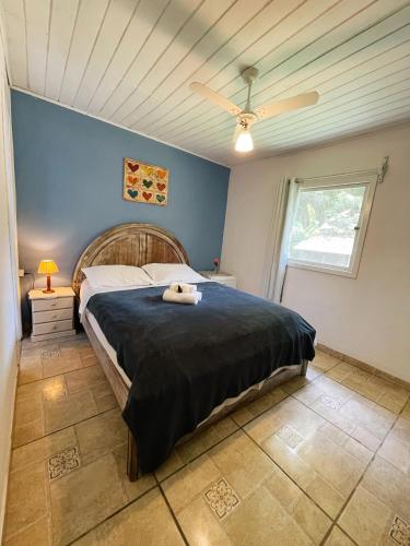 a bedroom with a bed and a ceiling fan at Pousada Casa Azul in Lumiar