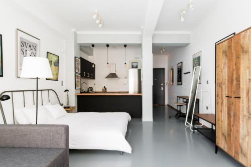 1 dormitorio con 1 cama y cocina en Explore a New Arts District from a Hip Studio Flat en Atenas