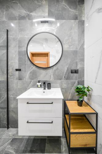 a bathroom with a white sink and a mirror at Apartament Komfort 17 in Zator