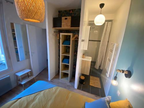 Habitación pequeña con cama y espejo. en Magnifique appartement T2 aux portes de Paris, en Cachan