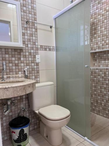 a bathroom with a toilet and a glass shower at Pousada Recanto da Paz in Lindóia