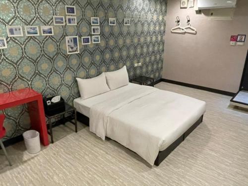 a bedroom with a bed and a wall with pictures at 苓旅萬年-LIN INN Wan Nian in Taipei
