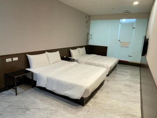 a hotel room with two beds and a television at 苓旅萬年-LIN INN Wan Nian in Taipei