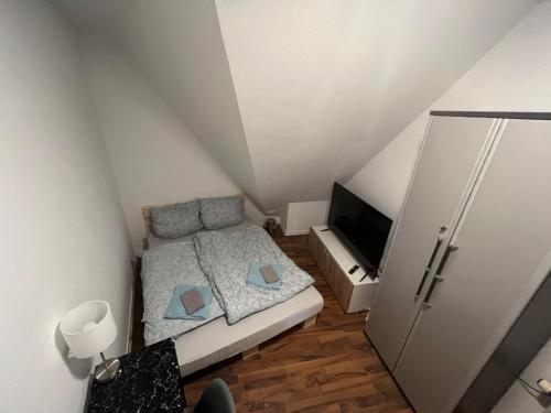 Zimmer in Innenstadtwohnung في فورتسبورغ: غرفة نوم صغيرة بها سرير وتلفزيون