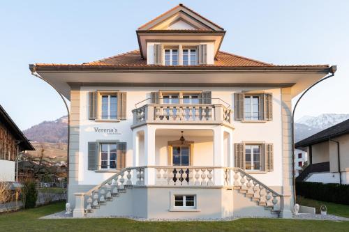 a large white house with a balcony at Verena's Boutique Villa au lac in Sachseln