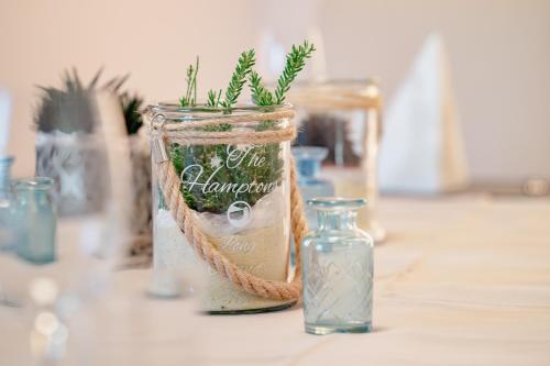 a jar with a plant in it sitting on a table at Verena's Boutique Villa au lac in Sachseln