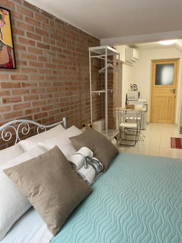 ein Schlafzimmer mit einem Bett mit Ziegelwand in der Unterkunft LAGUNA BLU Monolocale in Chioggia