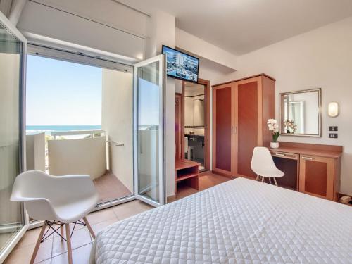 - une chambre avec un lit et une grande fenêtre dans l'établissement Hotel Colorado Cesenatico, à Cesenatico