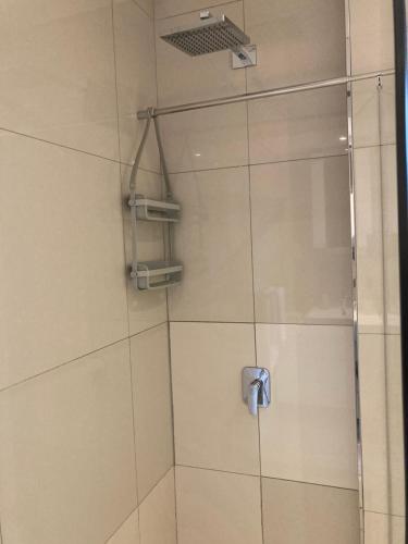 a shower with a glass door in a bathroom at Urban Awe Apartment- iTowers 18th Floor in Gaborone