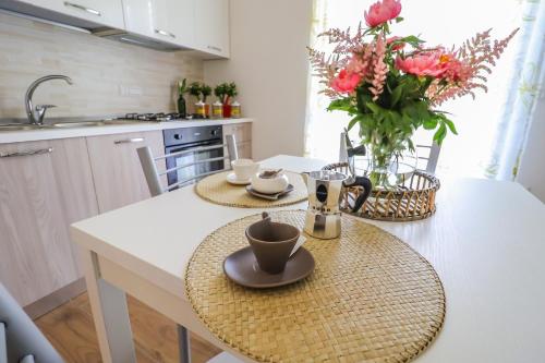 a kitchen with a table with two cups and a vase of flowers at Acquasanta Relais in Laureana Cilento