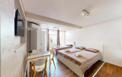 1 dormitorio con 2 camas, escritorio y TV en Markoni 5 en Burgas