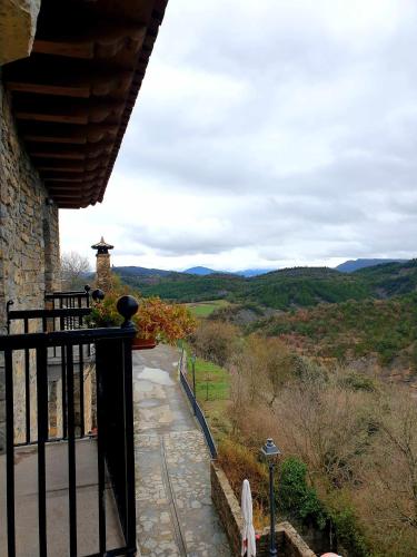 a balcony of a house with a view of the mountains at Hotel Rural LAbadia de Sieste in Sieste