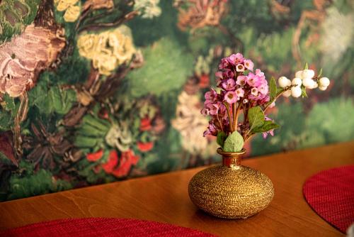 a vase with flowers in it sitting on a table at Boutique-Hotel Amalienhof in Weimar