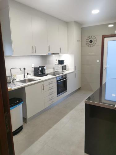 a kitchen with white cabinets and a sink at Angel by Prada City House in Vila Nova de Gaia
