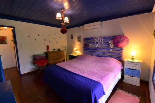 a bedroom with a purple bed and a wooden ceiling at Itaca delta cabañas in Tigre