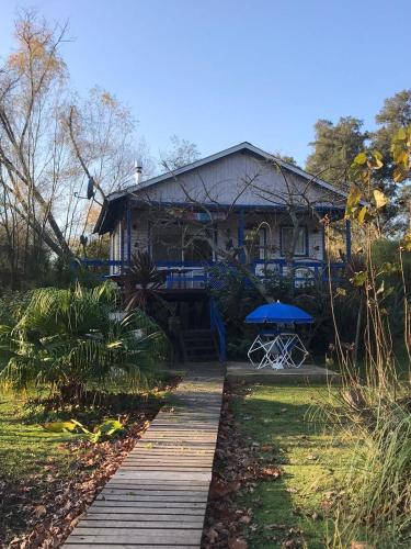 a house with a wooden walkway in front of it at Itaca delta cabañas in Tigre
