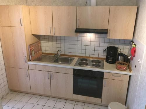 a kitchen with a sink and a stove top oven at Ferienwohnung 5, OG, Hof zur Sonnenseite Fehmarn in Sahrensdorf