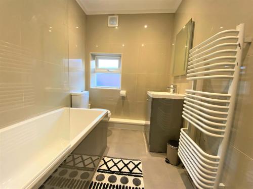een badkamer met een bad en een wastafel bij Dwell Living - Central 4 bedroom Contractor Family Friendly in Sunderland