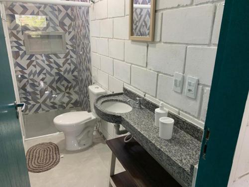 un baño con inodoro y lavabo en Casas Palha, en Maragogi