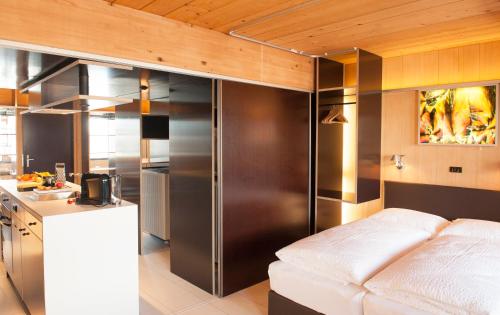 a kitchen with a stainless steel refrigerator and a white couch at Kar Design Appartements in Lech am Arlberg