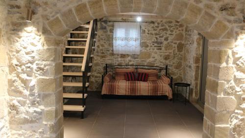 ein Schlafzimmer mit einem Bett in einer Steinmauer in der Unterkunft Mouri Village in Aïkiryiánnis