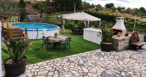 une arrière-cour avec une piscine, une table et des chaises dans l'établissement Casa Raiz Ponte de Lima, à Ponte de Lima