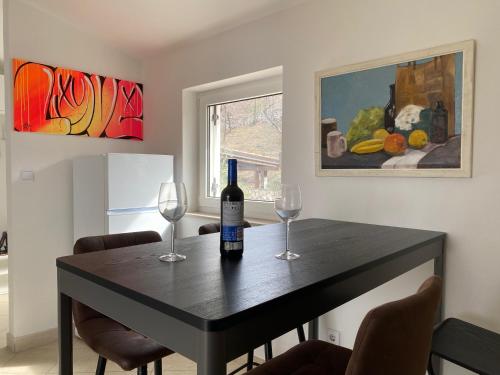 Una mesa con dos vasos y una botella de vino encima. en Sea View Apartment, 4 min. by foot to main beach, en Jadranovo