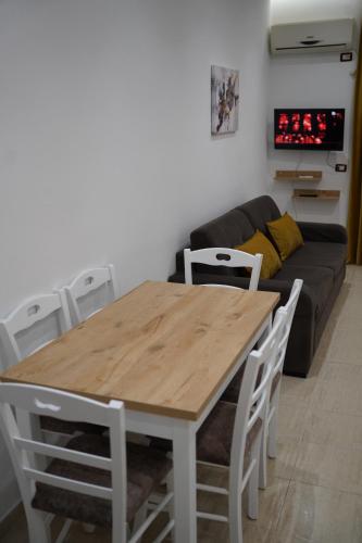 a table and chairs in a living room with a couch at Apartments Costa Azzurra in Velipojë