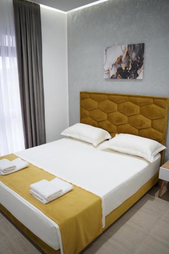 a bedroom with a large white bed with a yellow blanket at Apartments Costa Azzurra in Velipojë