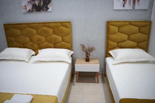 two twin beds in a room with a table at Apartments Costa Azzurra in Velipojë
