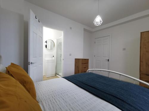 a white bedroom with a bed with a blue blanket at LOLO PROPERTIES 2, Free Parking in Edinburgh