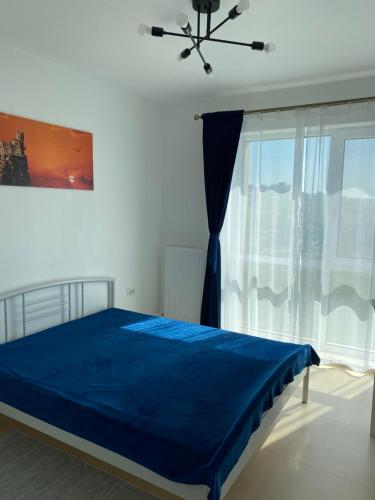 a bedroom with a blue bed and a window at Apartament Park View Campus in Constanţa