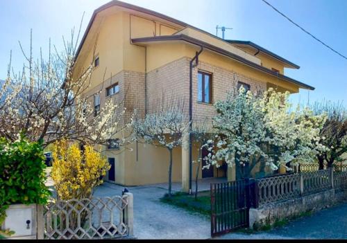 una casa amarilla con una valla delante de ella en Gubbio-Gualdo Tadino Incantevole mansarda con terrazza, en Gualdo Tadino