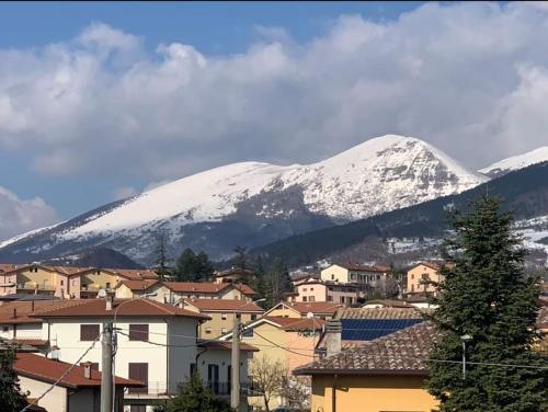 una ciudad con montañas cubiertas de nieve en el fondo en Gubbio-Gualdo Tadino Incantevole mansarda con terrazza, en Gualdo Tadino