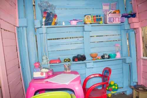 a pink and blue wall with a table and a chair at Vila Flores Pousada in Serra do Cipo