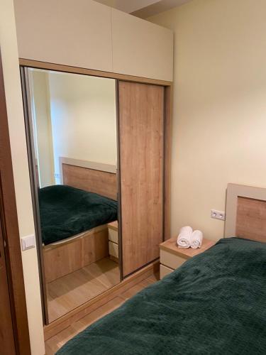 a small bedroom with a mirror and a bed at Lovely and cozy apartment! in Kutaisi