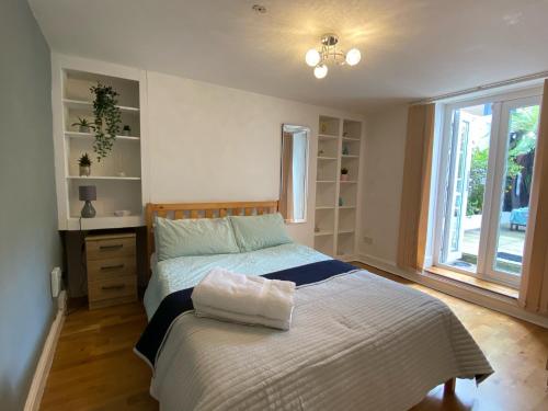 een slaapkamer met een groot bed en een raam bij Spacious 2-bed flat with garden, 3 minutes walk from Oval tube station in Londen