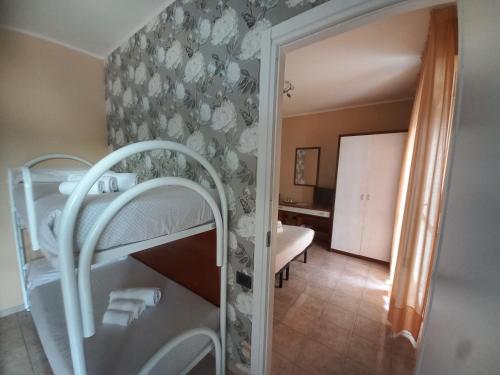 a bedroom with a bunk bed and a bathroom at Hotel Riva Etrusca in Marina di Bibbona